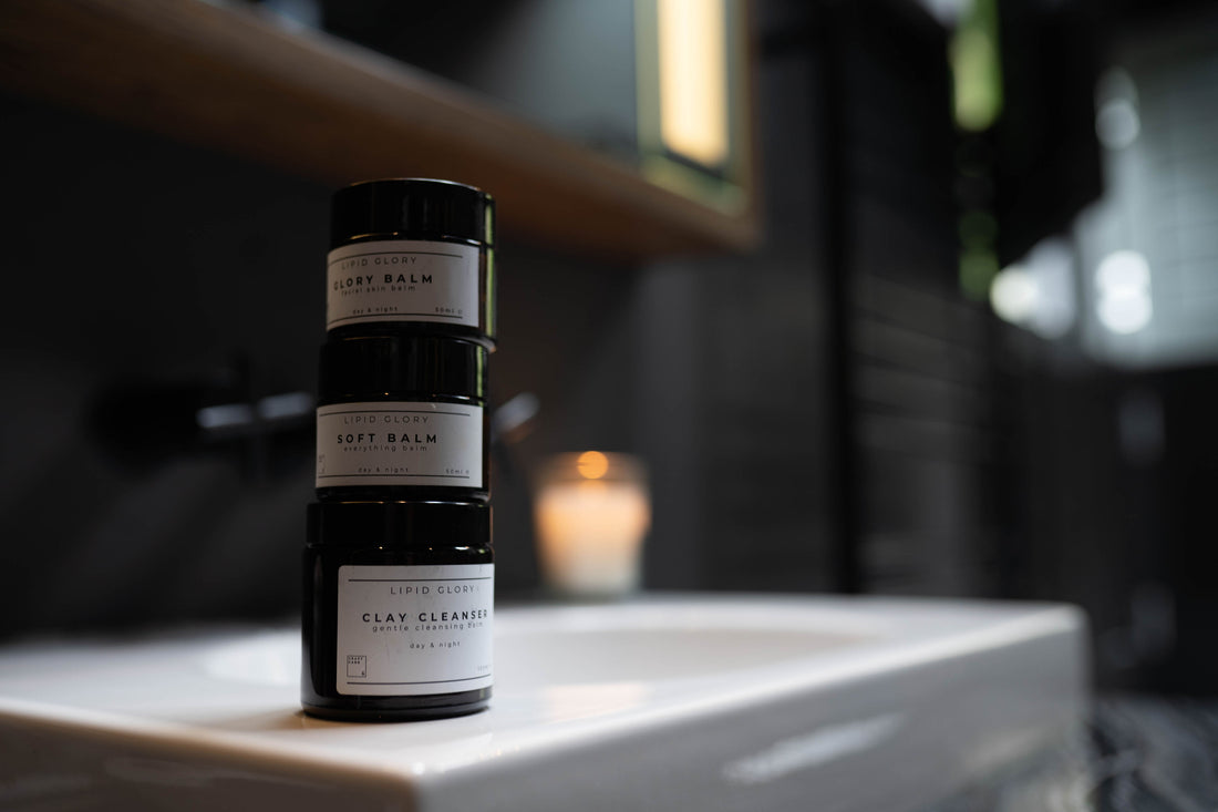 Drei Balsamtiegel stehen aufeinander gestapelt auf dem Waschbeckenrand