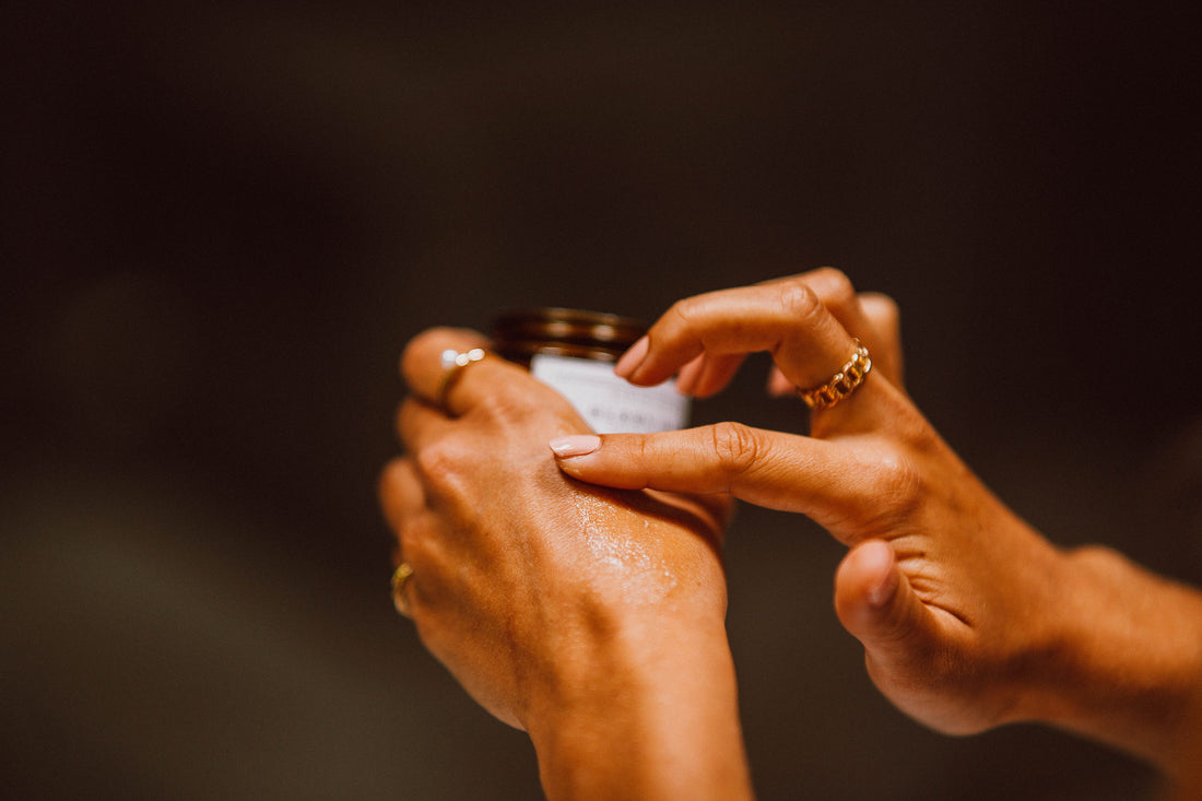 Frau trägt Balsam auf ihre Hand auf