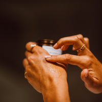 Frau trägt Balsam auf ihre Hand auf