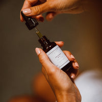 Frau entnimmt Jojobaöl mit Pipette aus der Flasche