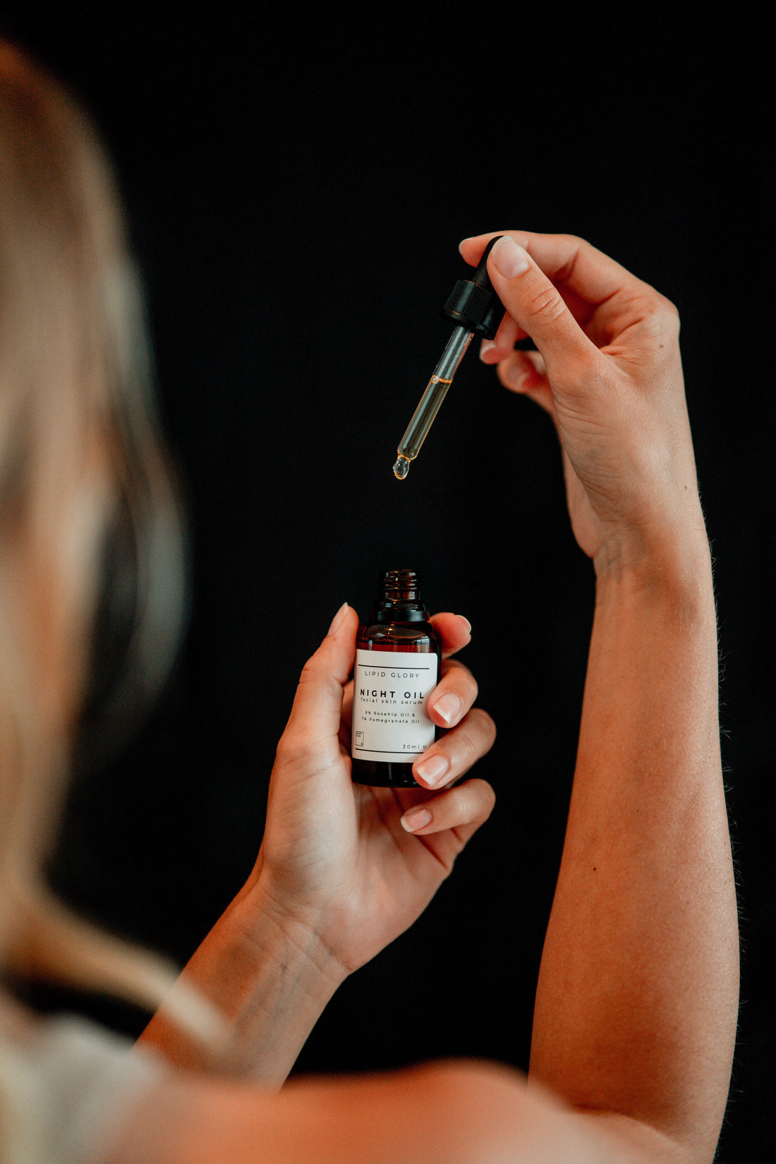 Frau entnimmt Nachtöl mit Pipette