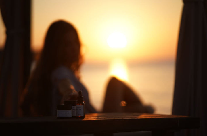 Frau sitzt im Sonnenuntergang